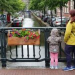 donna-e-bambino-in-piedi-su-un-ponte-nella-citta-di-amsterdam