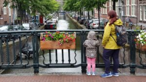donna-e-bambino-in-piedi-su-un-ponte-nella-citta-di-amsterdam