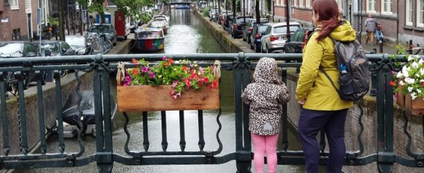 donna-e-bambino-in-piedi-su-un-ponte-nella-citta-di-amsterdam