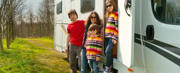 vacanze-in-famiglia-viaggi-in-camper-con-bambini-genitori-felici-con-bambini-in-viaggio-di-vacanza-in-camper