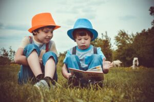 bambini all'aria aperta che leggono un libro